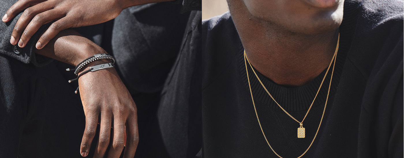 Black linear stacking bracelets and golden chains worn on models